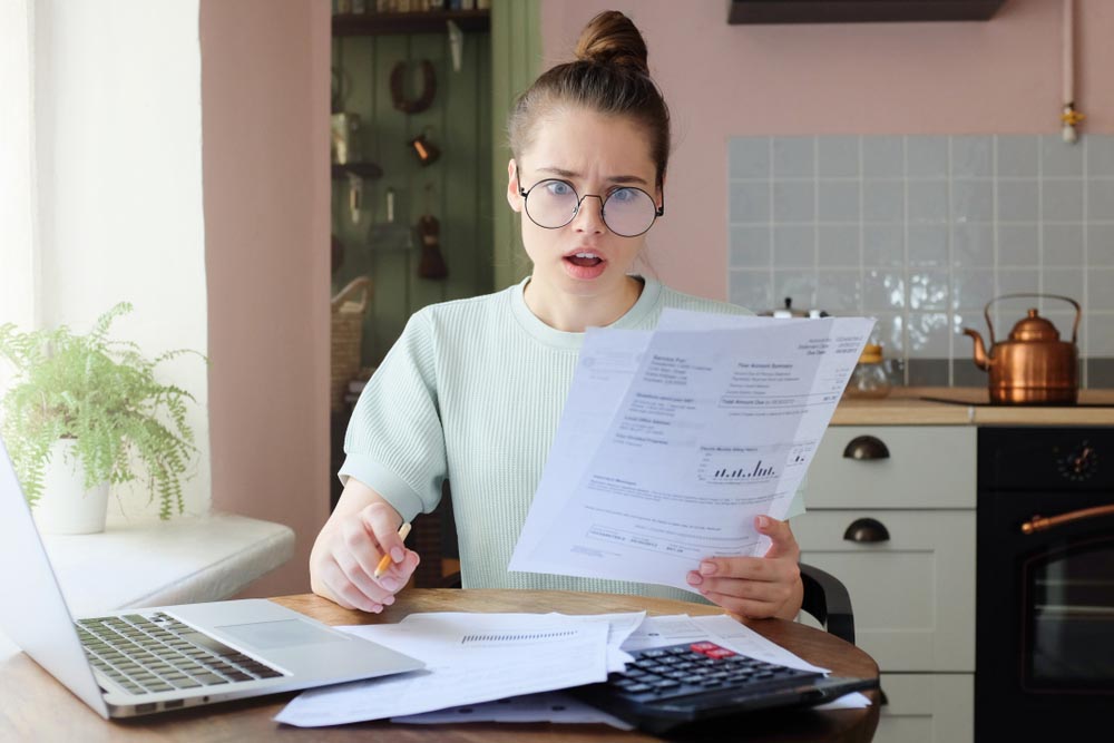 Person looking at an electric bill reading