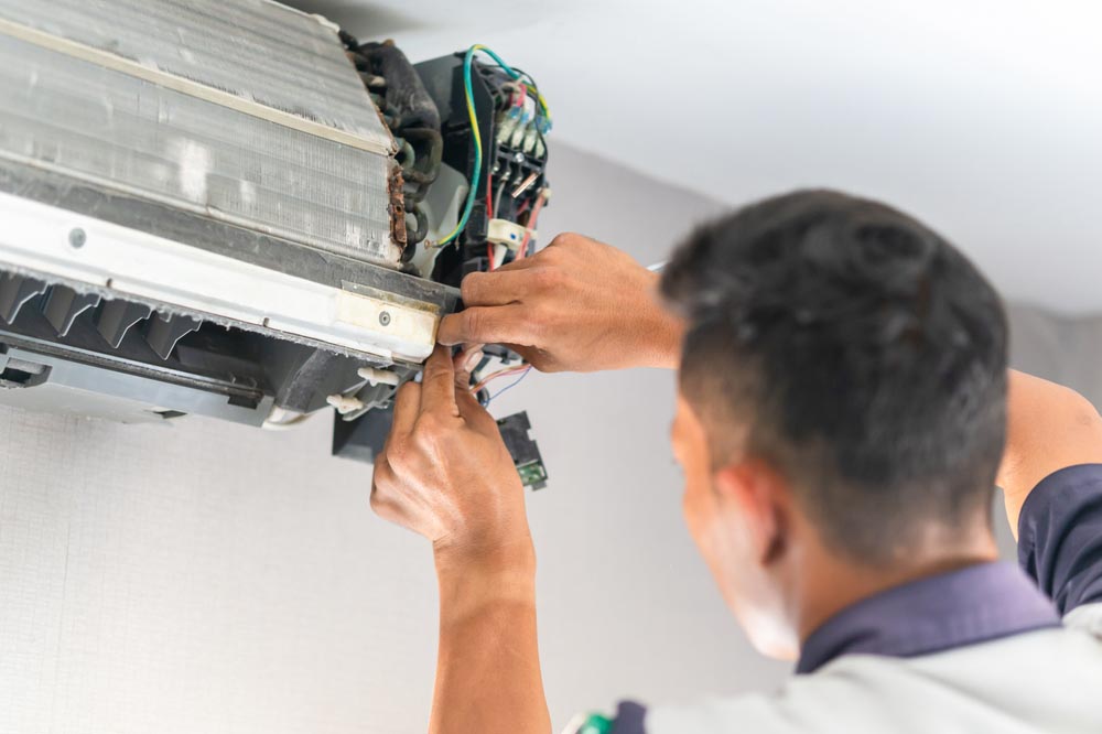 Technician tinkering with an AC unit
