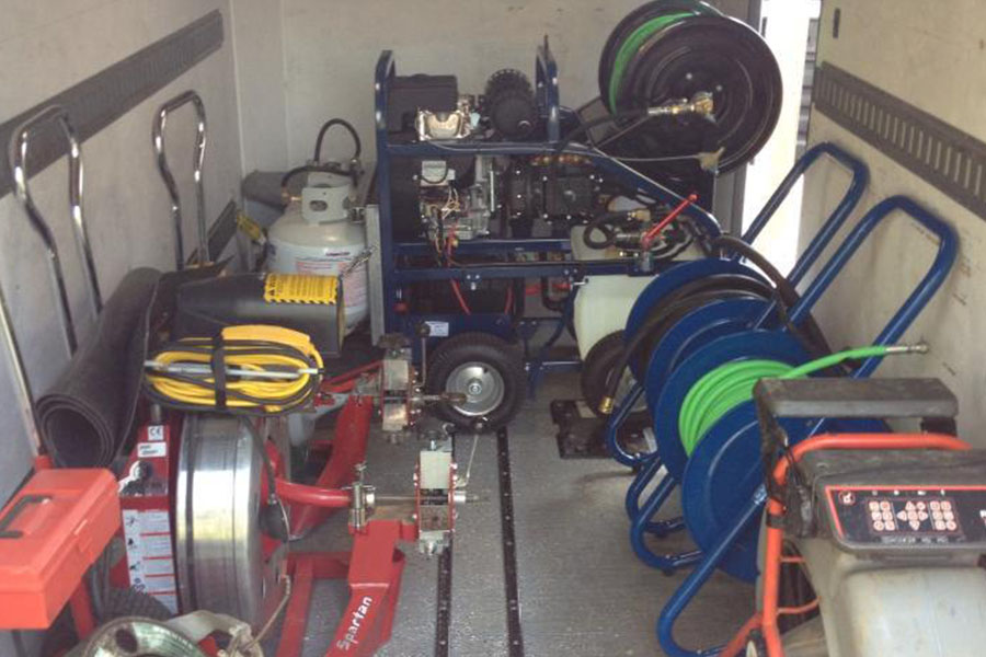 Sewer and drain cleaning equipment inside a utility vehicle, including jetting hoses and a Spartan machine