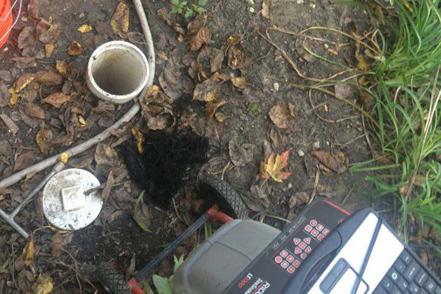 A plumbing technician's camera system inspecting a sewer line with root blockage