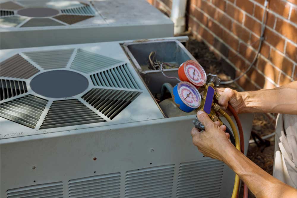 HVAC technician checking air conditioning unit with gauges