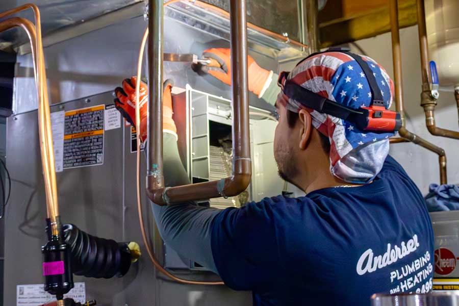 Andersen employee doing furnace repair