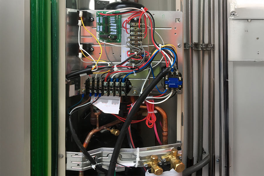 An open HVAC control panel with electrical wiring and circuit components.
