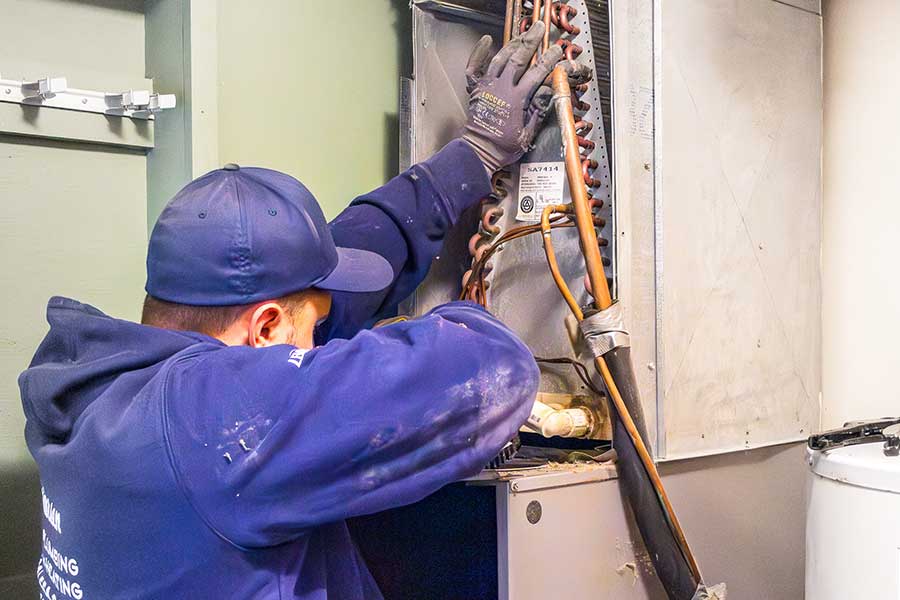 Heating technician inside furnace unit