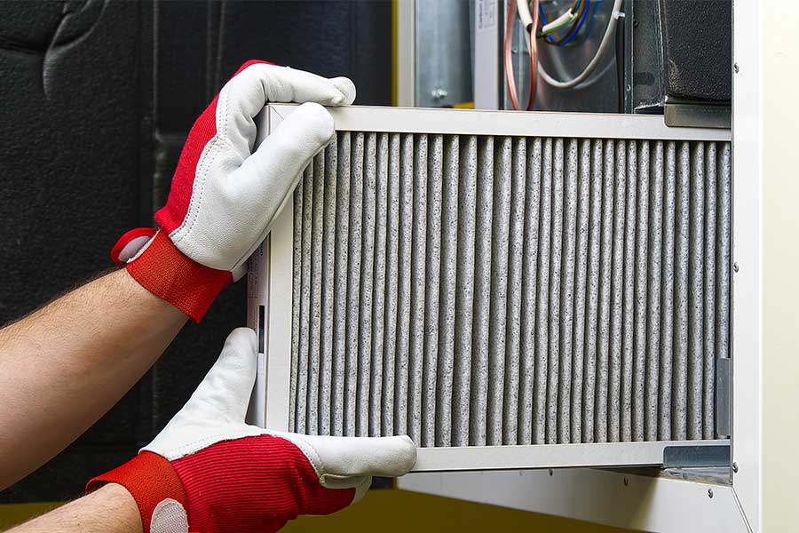 Dirty air filter being changed in a heating and cooling system.
