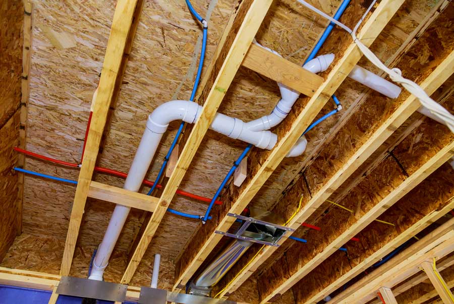 Exposed ceiling framing with plumbing and electrical installations