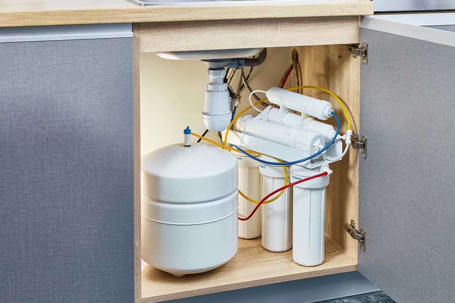 Multi-stage water filter and storage tank beneath a kitchen sink