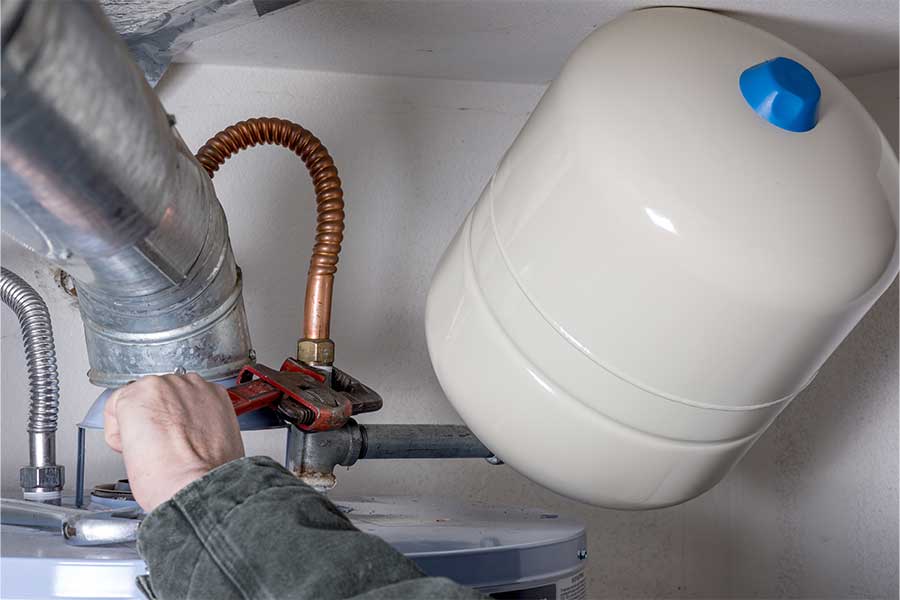 Hand adjusting a water heater vent and expansion tank setup