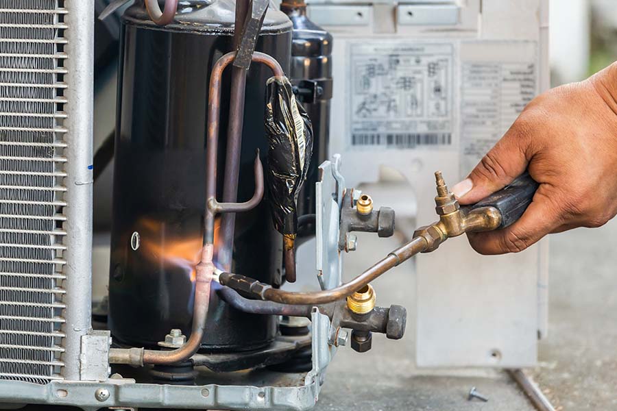 Technician brazing air conditioner pipes