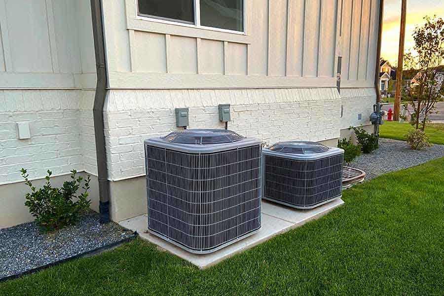 Two outdoor AC units beside house