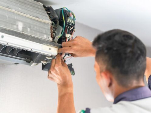 Technician tinkering with an AC unit